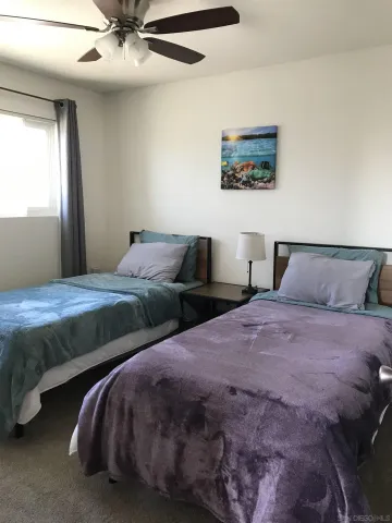 a bedroom with two beds and painting on the wall