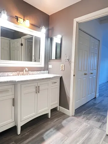 a spacious bathroom with a granite countertop sink and a mirror