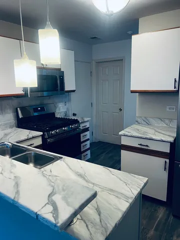 a kitchen with kitchen island a sink appliances and cabinets