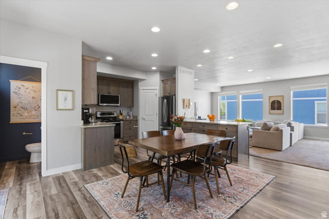 370 West Knights Lane Layton, UT 84041 - Photo 6 of 31 Open-concept living space featuring wood-finish flooring, recessed lighting, and a modern kitchen with a large island and stainless steel appliances