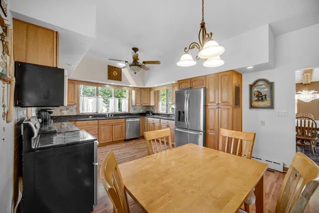 a kitchen with sink refrigerator dining table and chairs