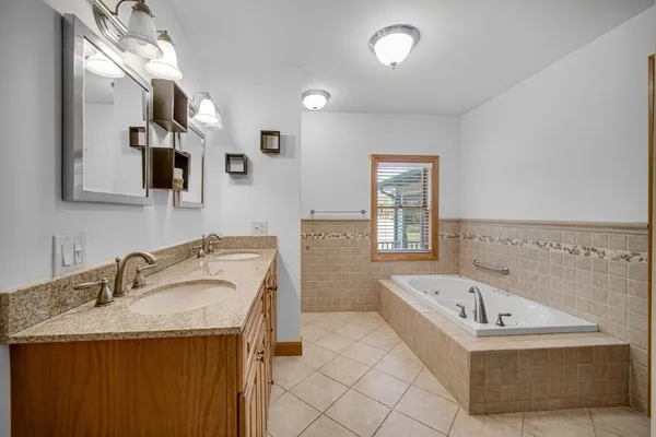 a bathroom with a granite countertop sink and a bathtub