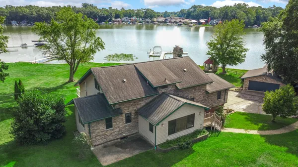 an aerial view of a house with garden space and a patio