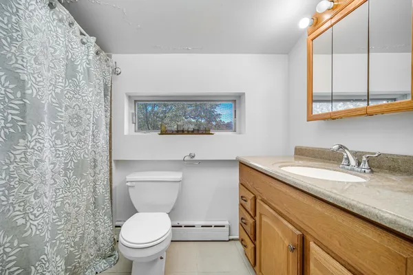 a bathroom with a granite countertop toilet sink and a mirror