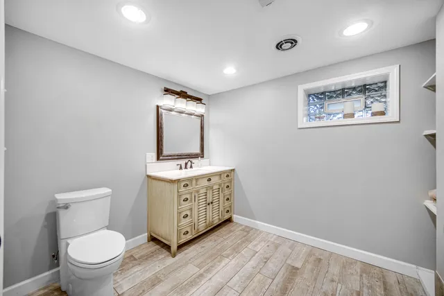 a bathroom with a toilet sink and mirror