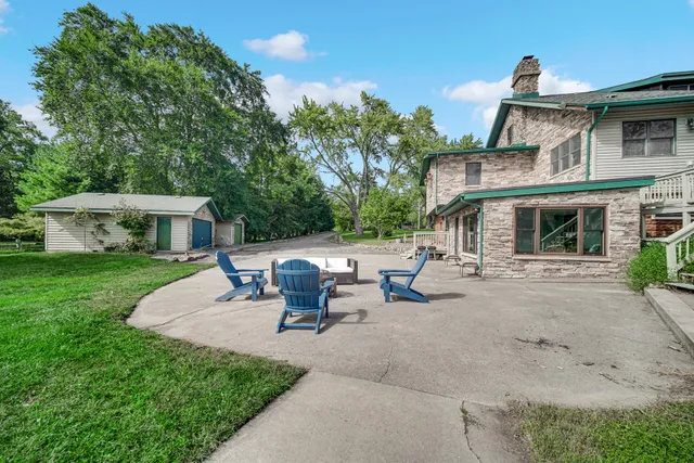 a front view of a house with big yard and large trees