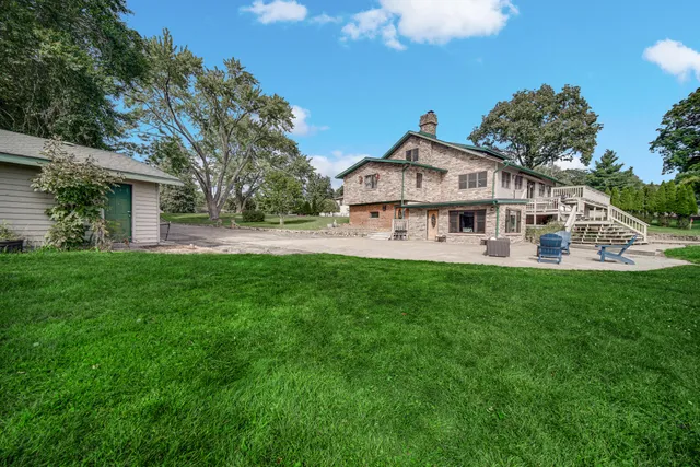 a view of a house with a big yard and a fountain