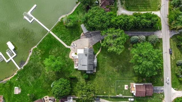 an aerial view of residential house with outdoor space and trees all around