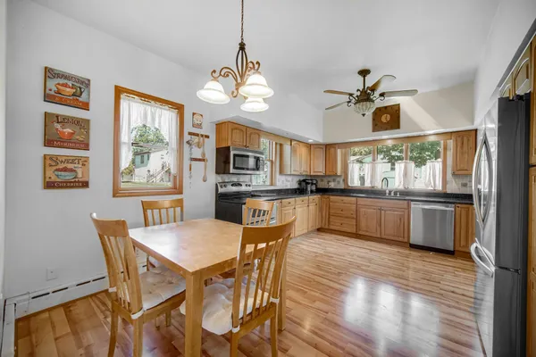 a view of a dining room with furniture a kitchen and chandelier