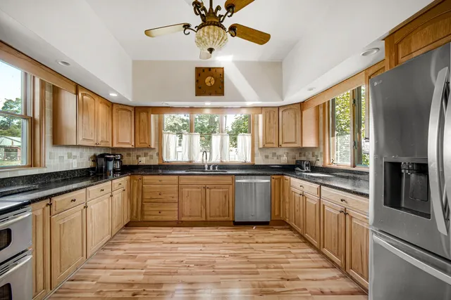 a large kitchen with stainless steel appliances granite countertop a stove and refrigerator