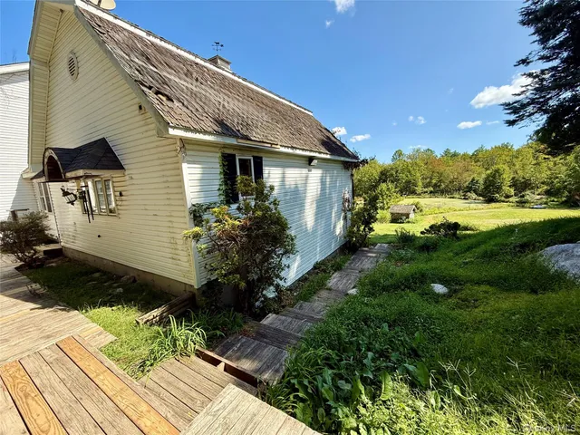 a backyard of a house with potted plants and wooden fence