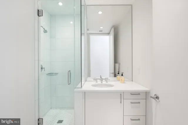 a bathroom with a shower sink vanity and mirror