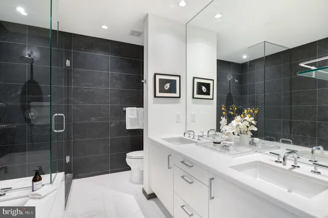 a bathroom with a double vanity sink mirror and shower