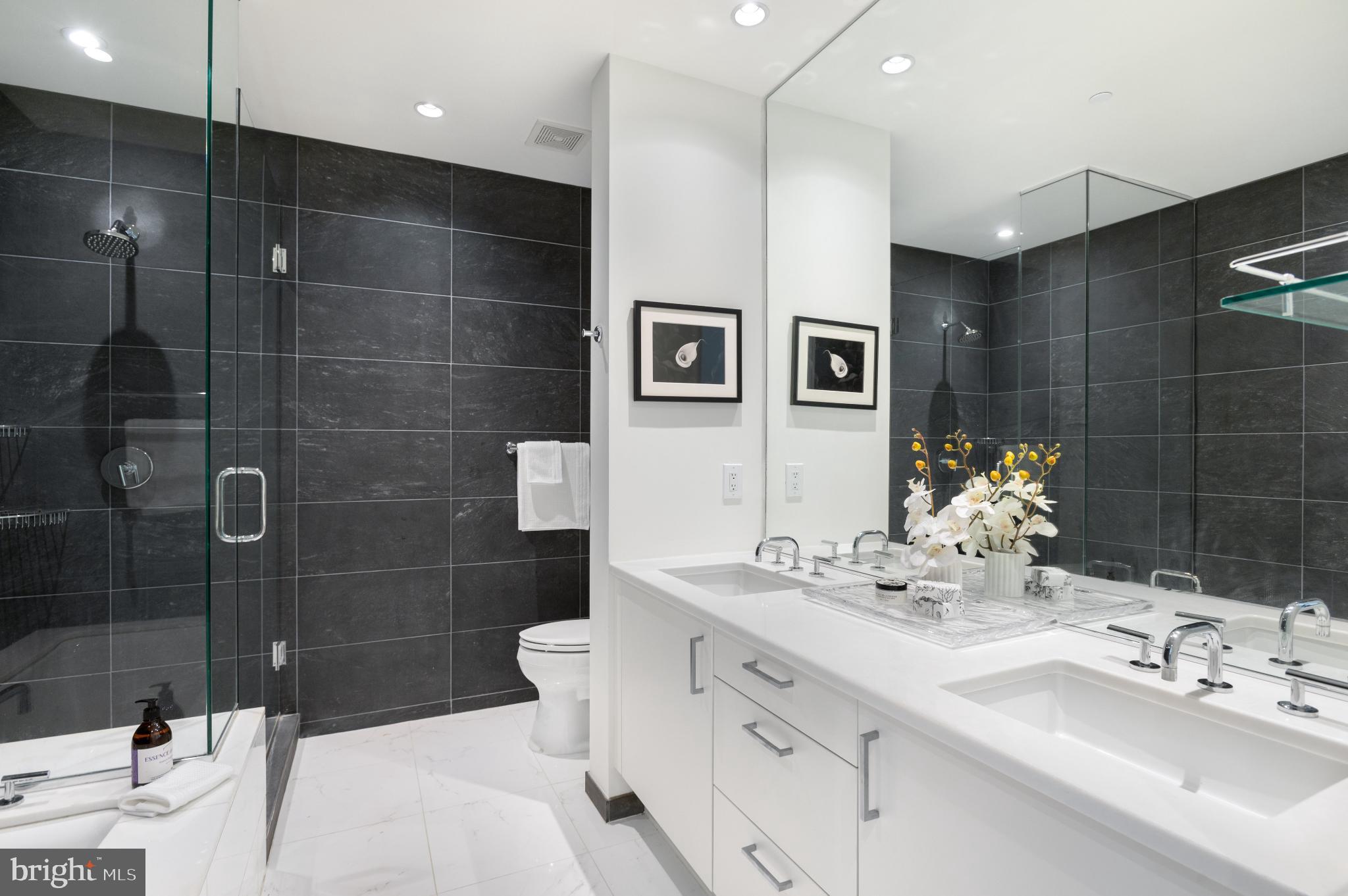 1177 22nd Street Northwest, Unit 2K Washington, DC 20037 - Photo 9 of 21 a bathroom with a double vanity sink mirror and shower