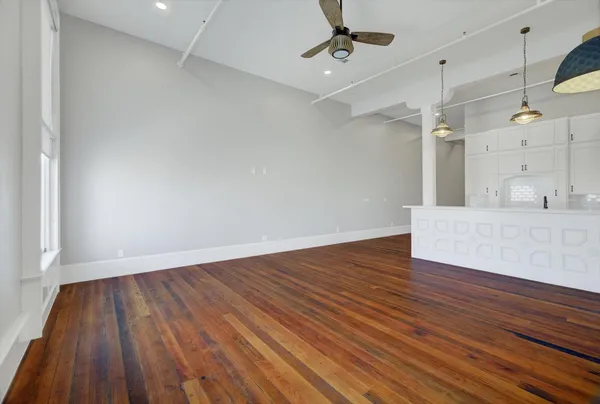 a view of a room with wooden floor and a ceiling fan