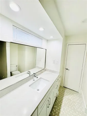 a spacious bathroom with a double vanity sink and a mirror