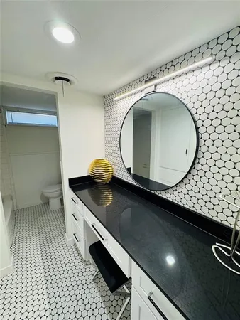closeup of a sink with granite countertop a sink a mirror and vanity