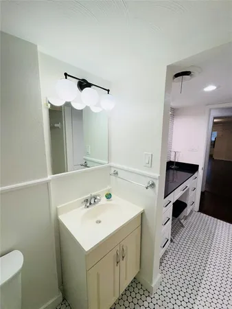a bathroom with a sink a toilet and a mirror