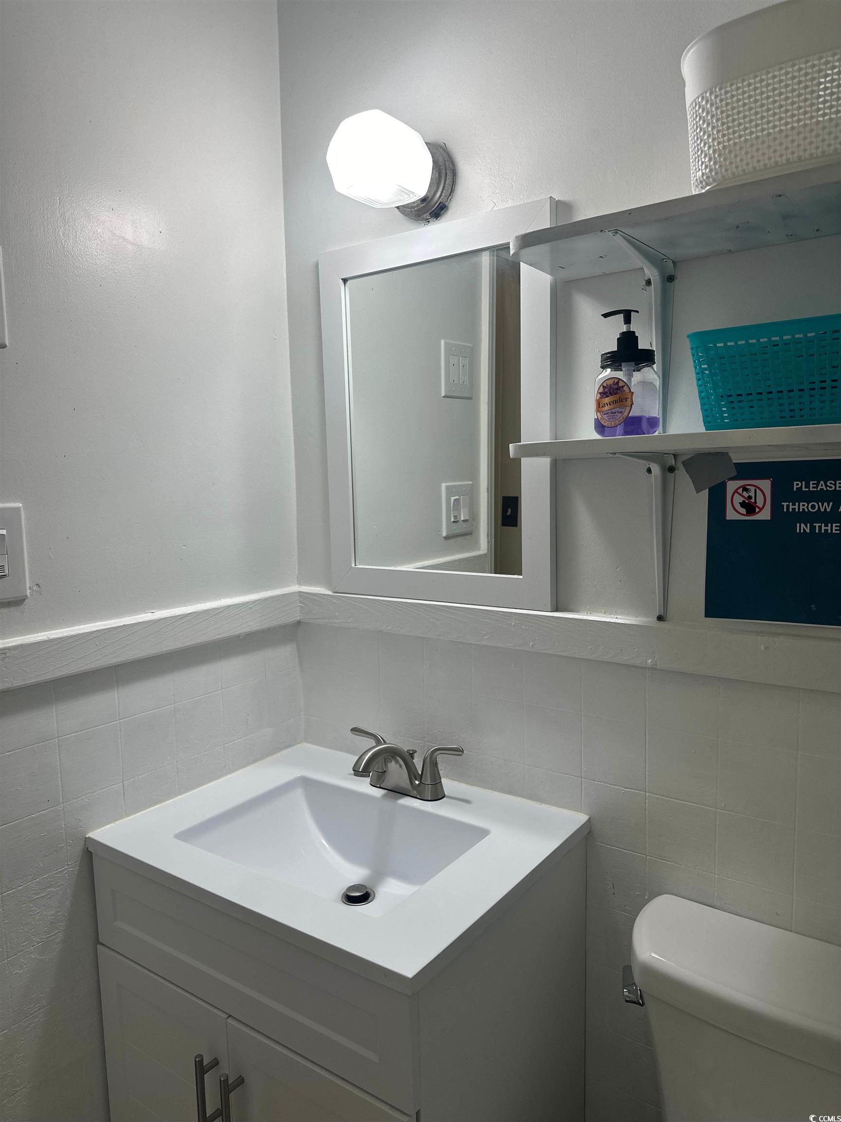 519 32nd Avenue North Myrtle Beach, SC 29577 - Photo 15 of 25 Bathroom with tile walls, vanity, and a wainscoted wall