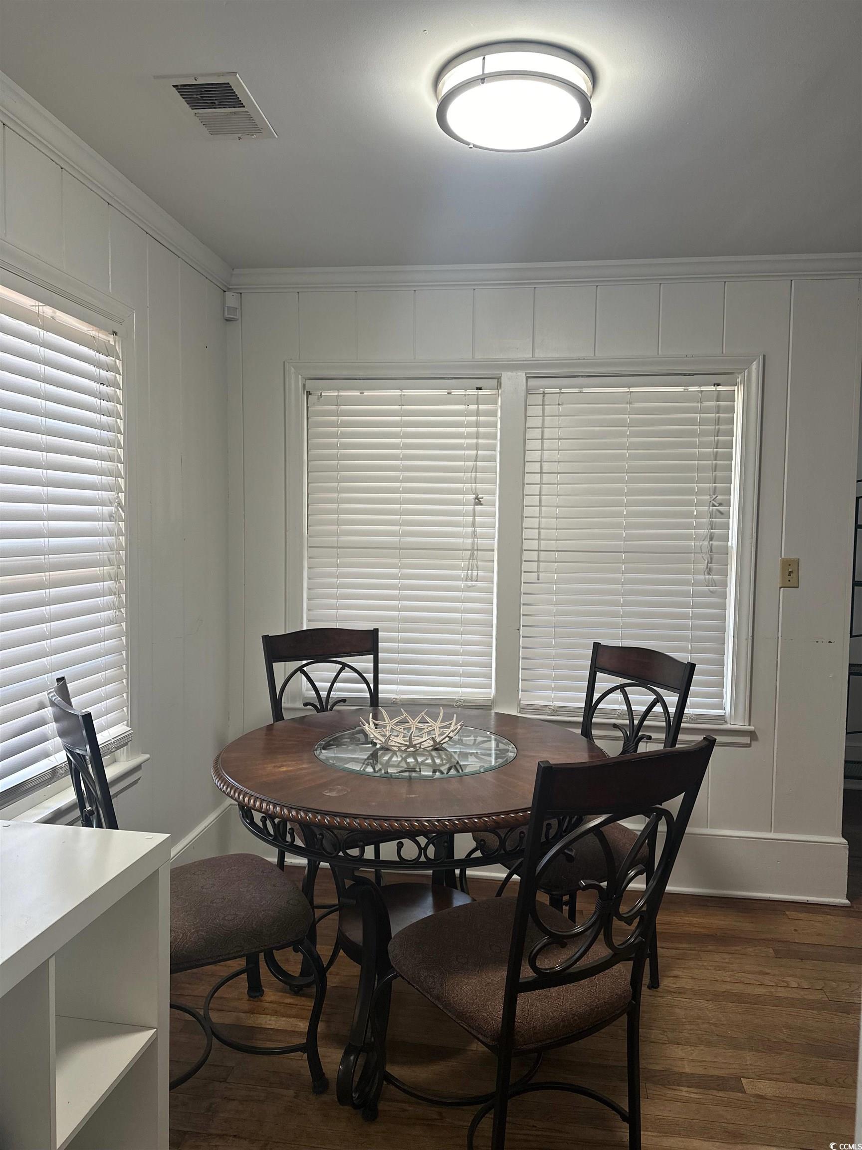 519 32nd Avenue North Myrtle Beach, SC 29577 - Photo 7 of 25 Dining space with crown molding and dark wood-style flooring