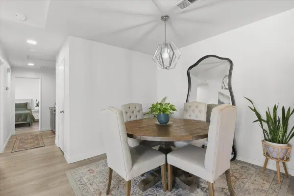a bedroom with a bed and a potted plant on the dresser