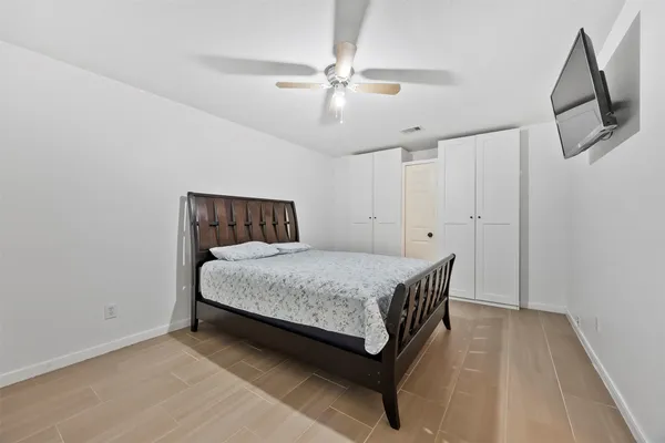 a bedroom with a bed and a ceiling fan