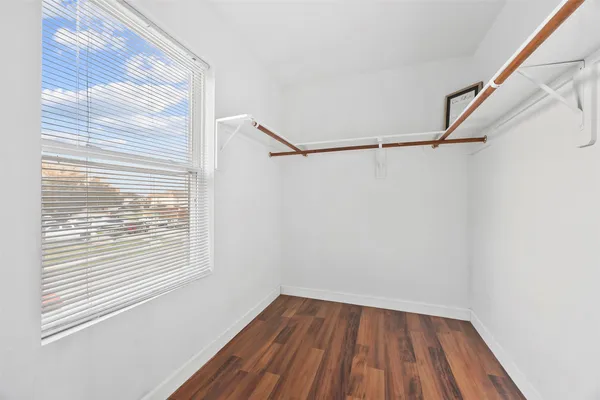 a view of a room with wooden floor and small window