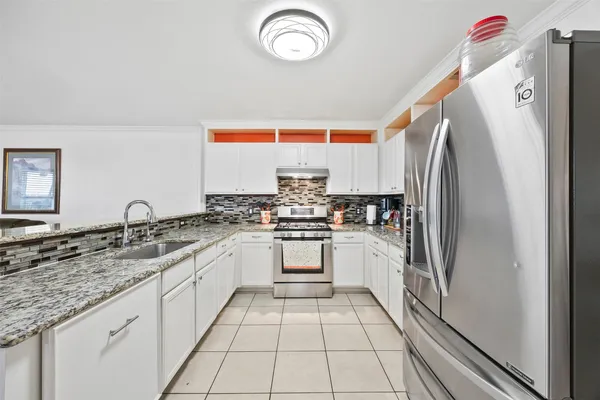 a kitchen with granite countertop a refrigerator and a sink