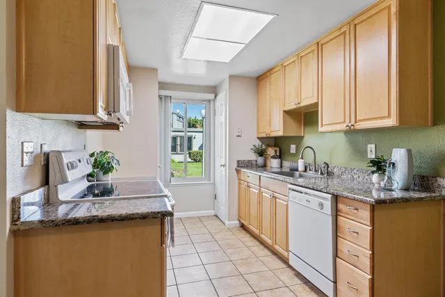 a kitchen with stainless steel appliances granite countertop a sink stove and cabinets