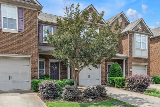 front view of a house with a yard and an trees