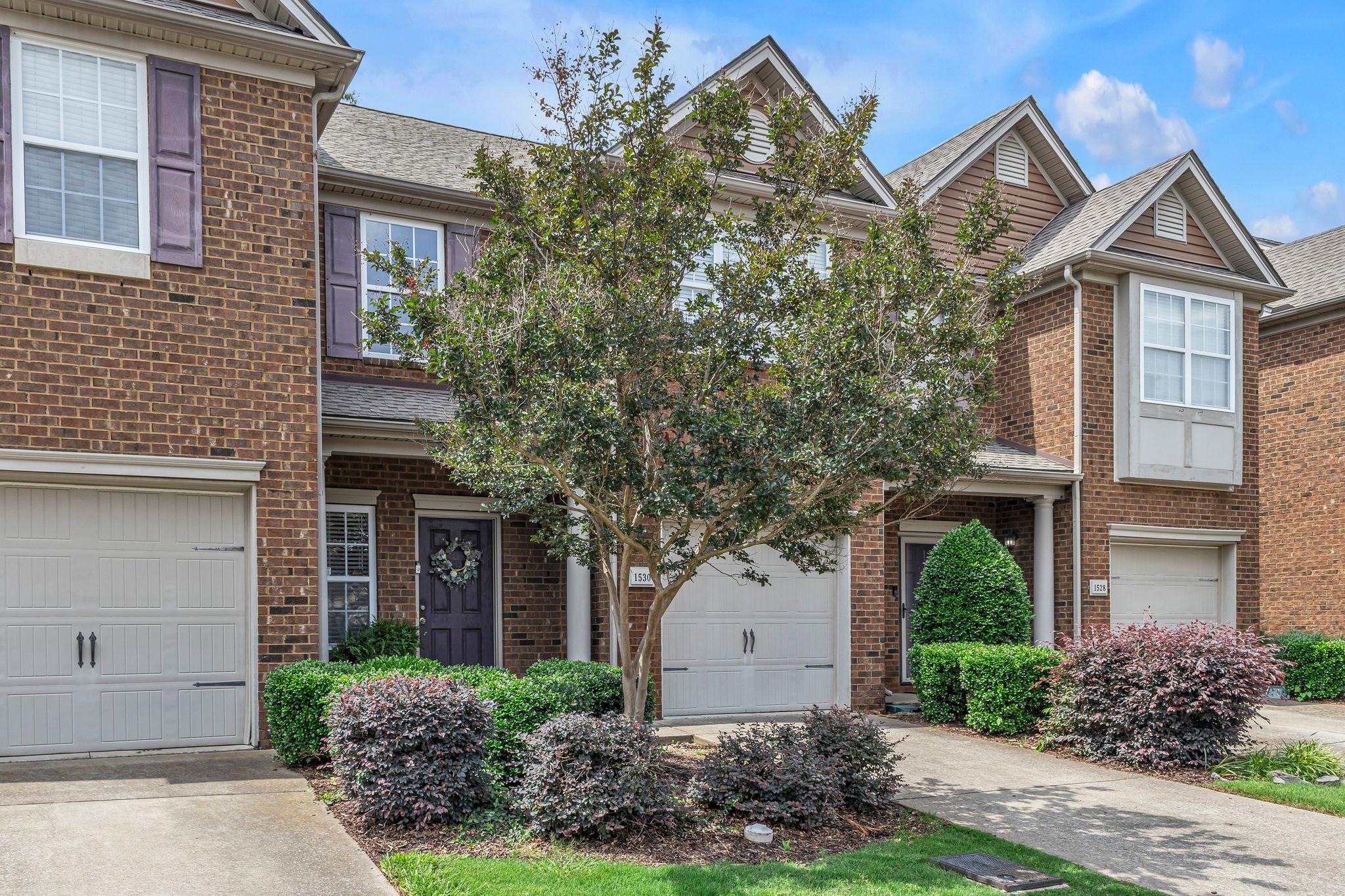 front view of a house with a yard and an trees
