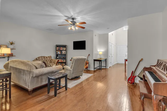 a living room with furniture a ceiling fan and a rug