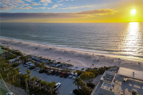 an aerial view of ocean and residential houses with outdoor space