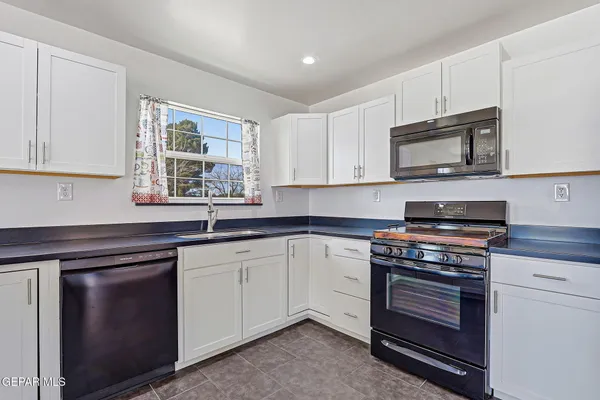 a view of an empty room with wooden floor and cabinet
