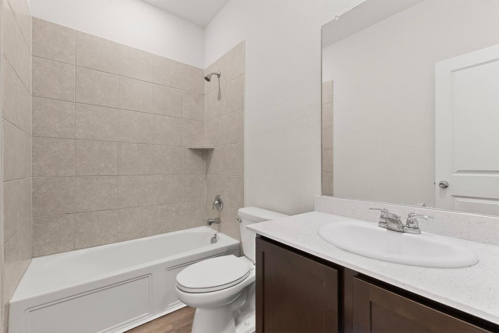 3321 Riverside Drive Aubrey, TX 76227 - Photo 16 of 40 a bathroom with a sink a toilet and bathtub