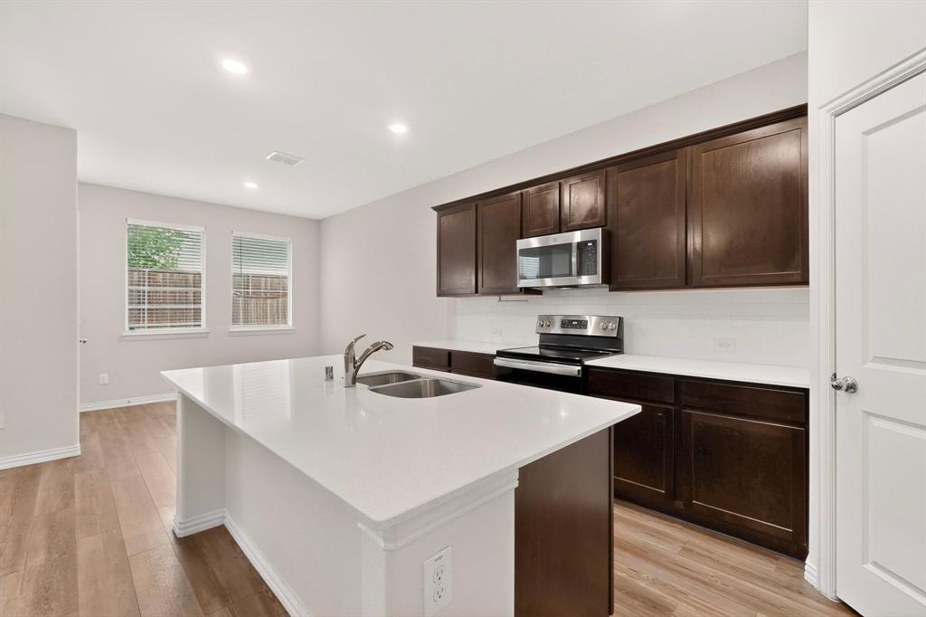 3321 Riverside Drive Aubrey, TX 76227 - Photo 10 of 40 a kitchen with a sink a microwave and cabinets