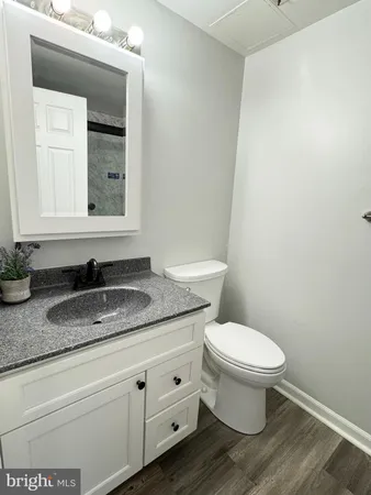 a bathroom with a granite countertop toilet and sink
