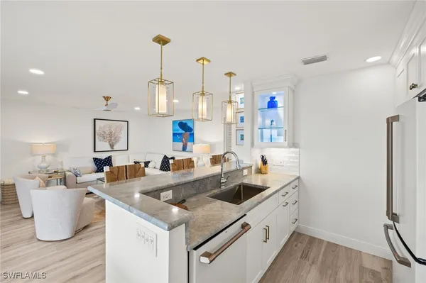 a kitchen that has a sink a stove and chairs