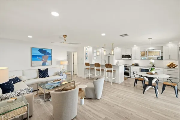 a living room with lots of furniture and kitchen view