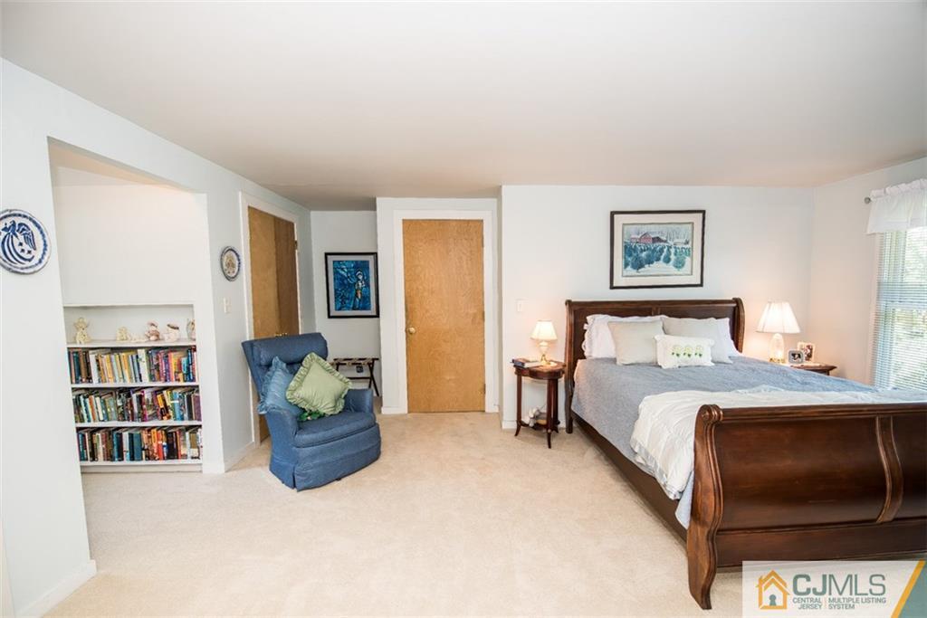 91 Conover Road West Windsor, NJ 08550 - Photo 19 of 25 a bedroom with a bed and lots of painting on the wall