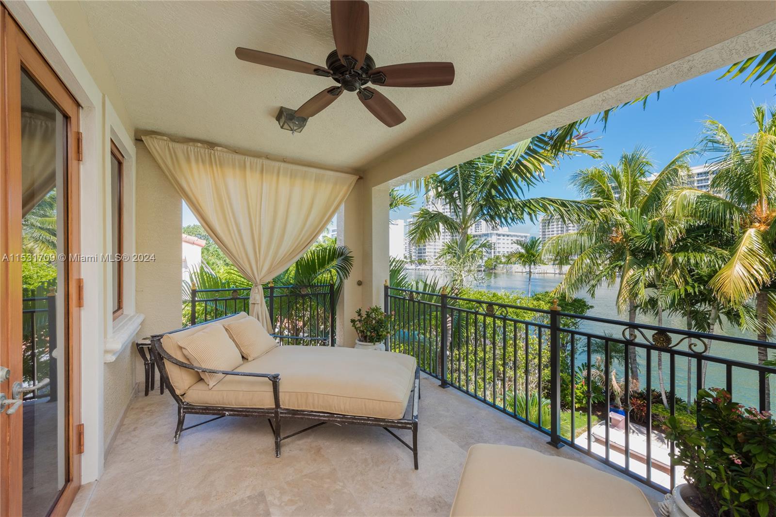 5655 Pine Tree Drive Miami Beach, FL 33140 - Photo 18 of 21 a balcony with furniture and a potted plant