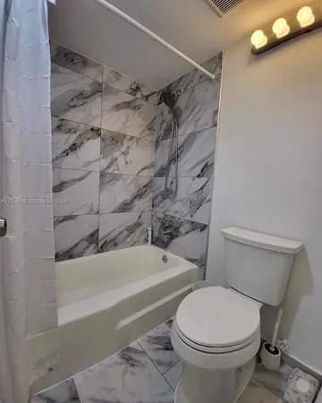 a bathroom with a toilet and a shower