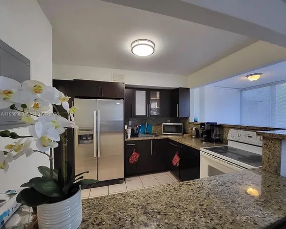 a kitchen with granite countertop a refrigerator sink and stove