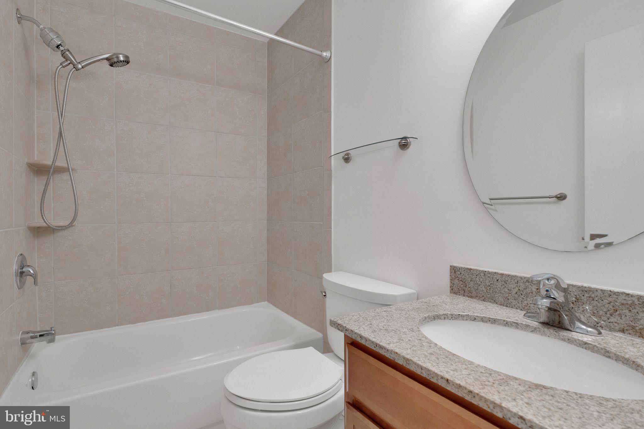 6002 Mardale Lane Burke, VA 22015 - Photo 18 of 28 a bathroom with a granite countertop sink toilet and shower