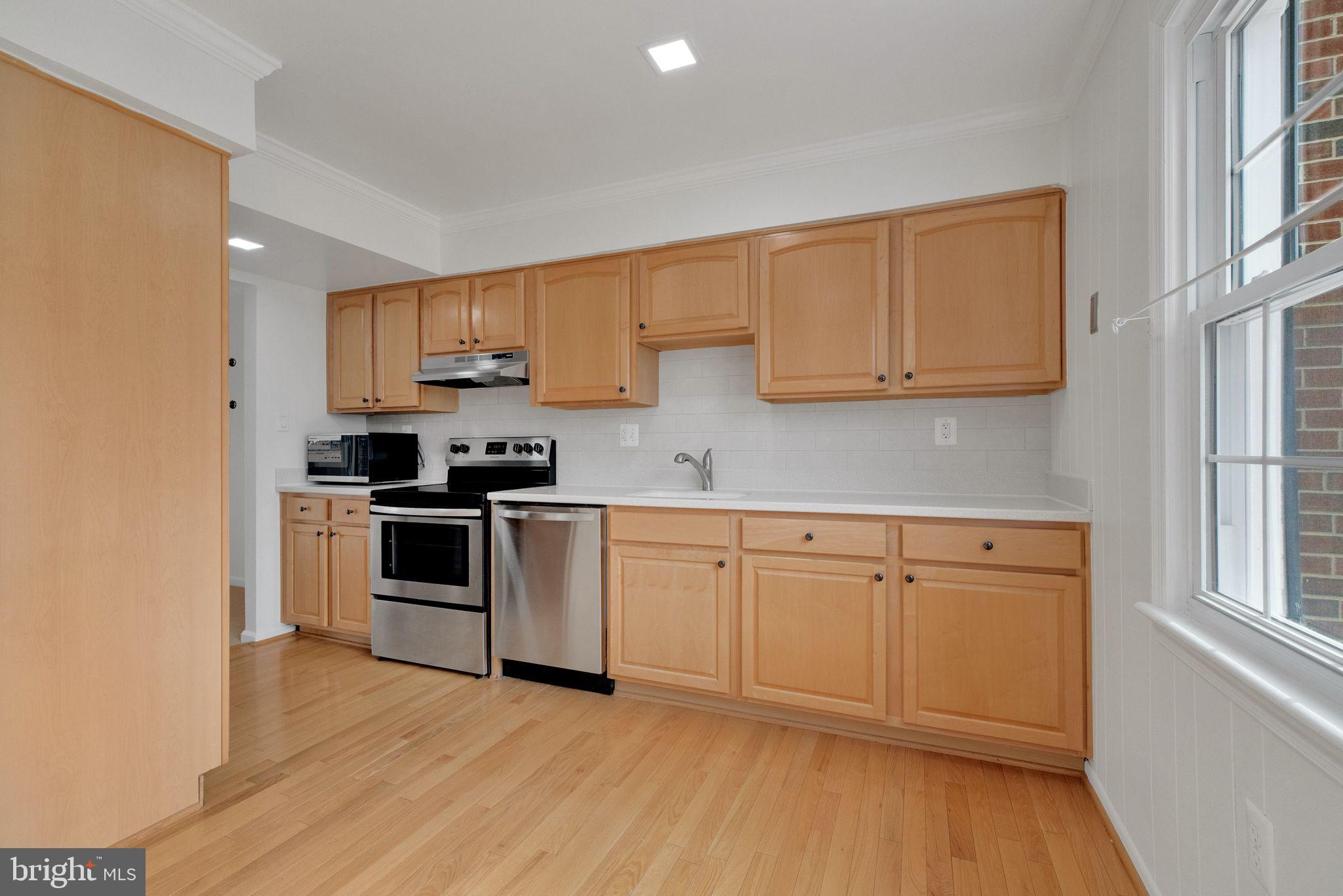 6002 Mardale Lane Burke, VA 22015 - Photo 7 of 28 a kitchen with granite countertop white cabinets and white appliances