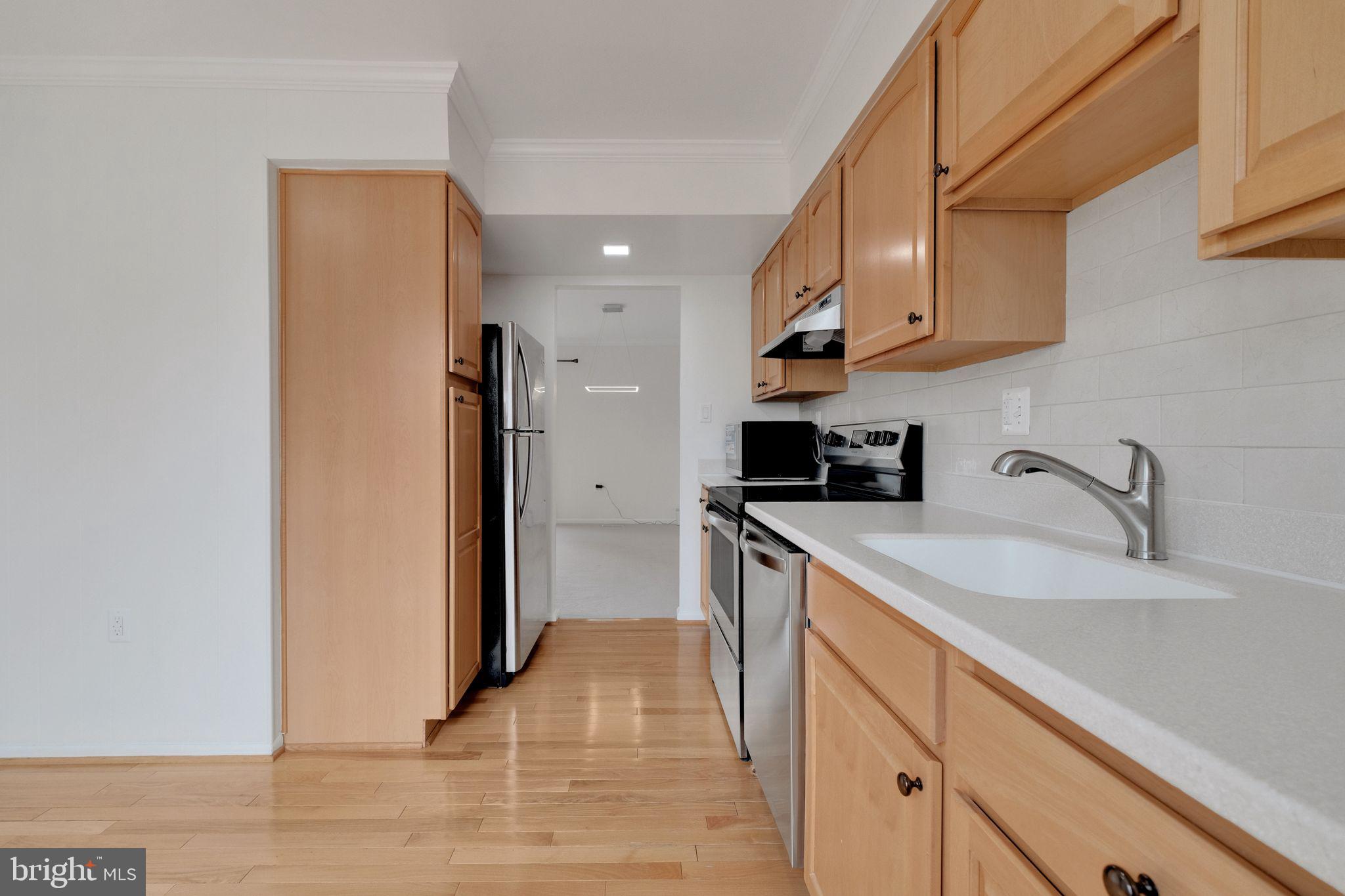 6002 Mardale Lane Burke, VA 22015 - Photo 10 of 28 a kitchen with a sink a refrigerator and cabinets