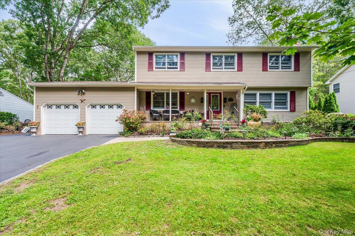 677 Meadow Road Smithtown, NY 11787 - Photo 1 of 1 View of front of house with a porch, a garage, asphalt driveway, and a front yard