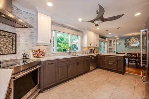 a large kitchen with stainless steel appliances granite countertop a stove and a sink
