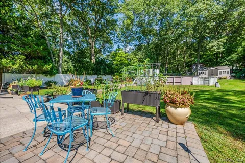 a backyard of a house with table and chairs and potted plants