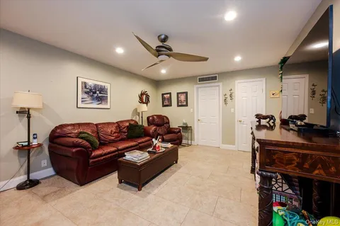 a living room with furniture a ceiling fan and a rug